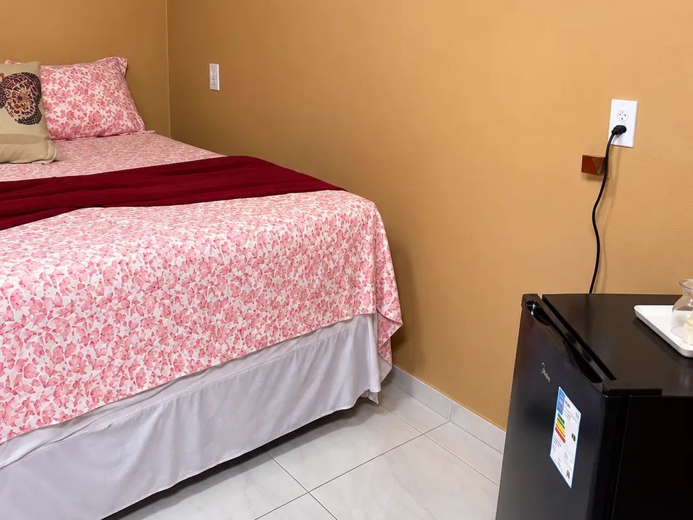 Quarto com cama de casal e frigobar