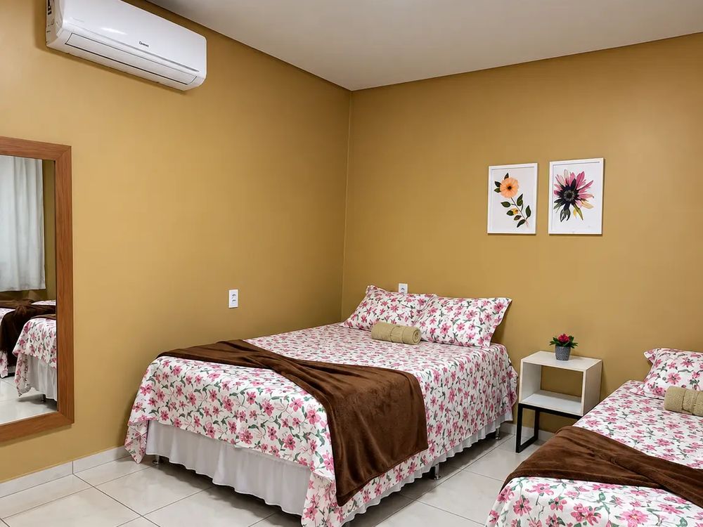 Quarto com duas camas de casal e ar-condicionado